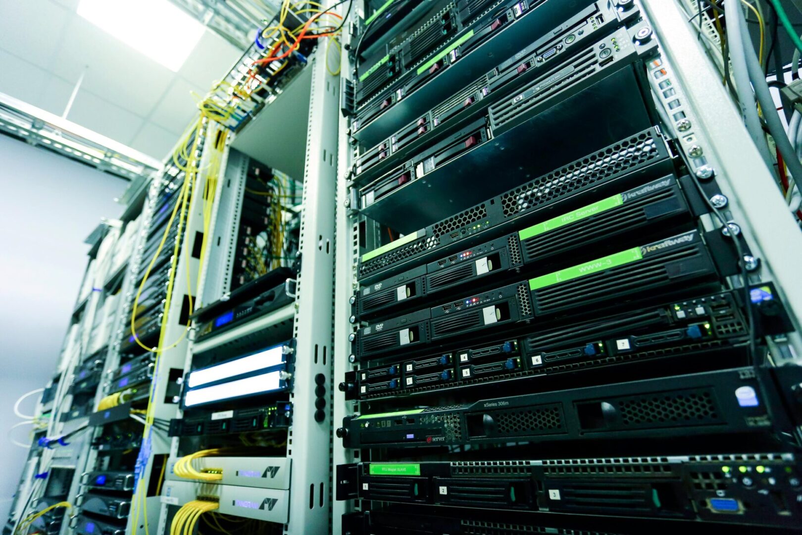A rack of servers in a room with wires.